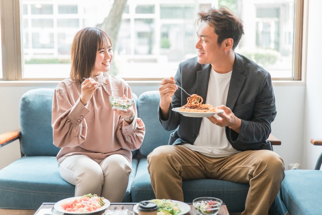 女性と男性が食事をしている画像